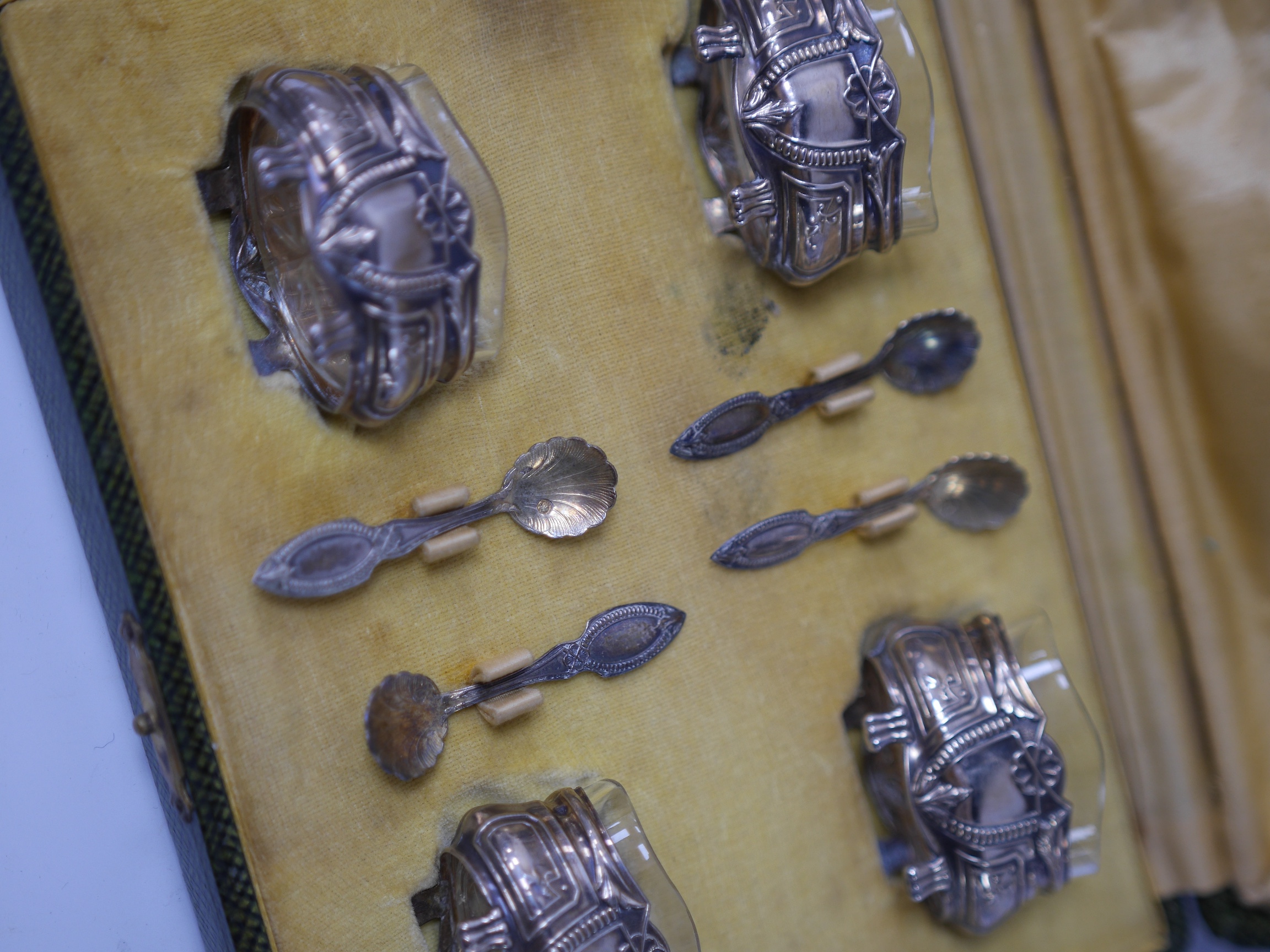 A cased set of four late 19th/early 20th century French 800 standard white metal oval salts with glass liners and four matching spoons, length 46mm. Condition - fair to good